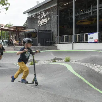 Un enfant en trottinette s'entraine sur le pumptrack à Charmey